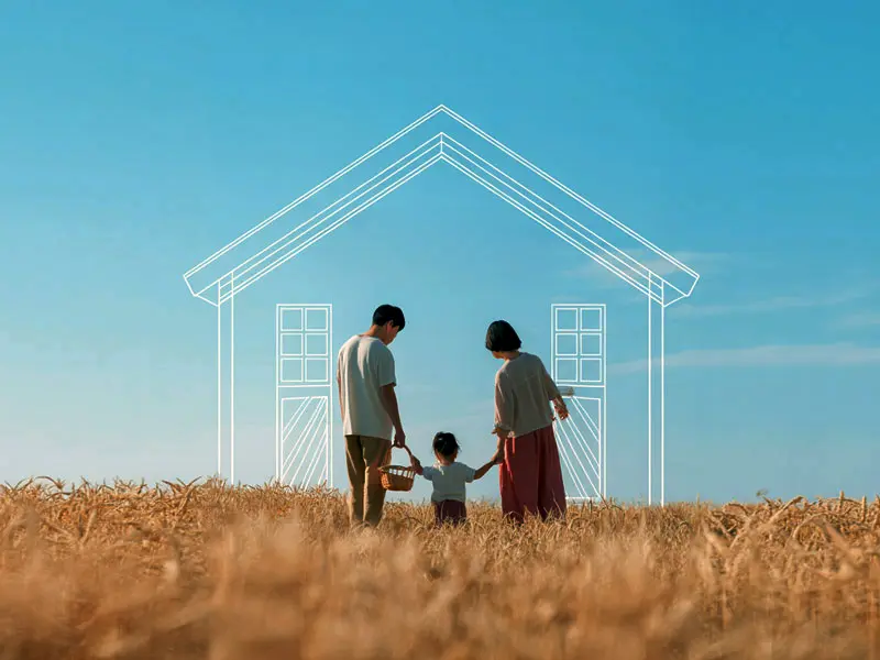 Familie auf einem Feld vor einem skizzierten Haus – Immobilien-Träume realisieren